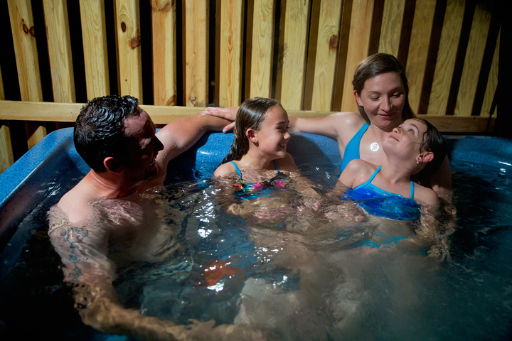 Family relaxes in private hot tub