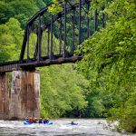 Rafters paddle beneath historic New River railroad trestle