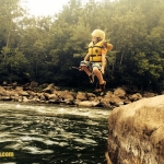 A youth leaps into the New River