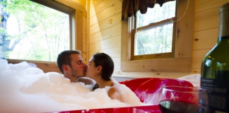 A couple soaks in a heart-shaped tub at County Road Cabins