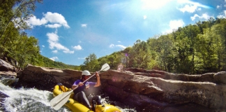 A paddler in an inflatable kayak challenges the Dries of the New River.