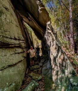 Hikers pass through cave.