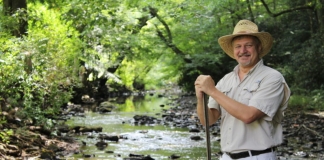 David Sibray pauses along a mountain stream in West Virginia, the landscape he's been promoting professionally for 30 years.