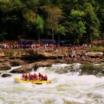 Rafters outfitted with River Expeditions watch raft-load plow through Sweets Falls on the Gauley River.