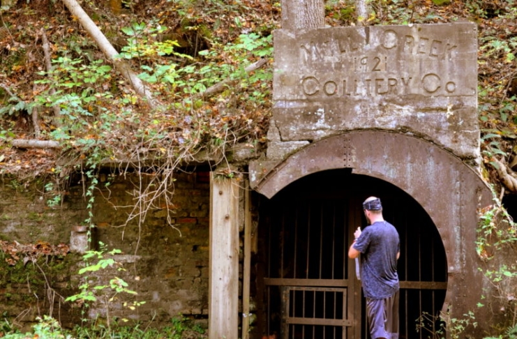 A gated mine opening along a rail trail near Ansted, West Virginia, attracts an interested hiker.