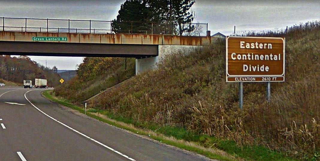 A sign recognizing the Eastern Continental Divide rises along I-68 in Maryland. Google Maps image.