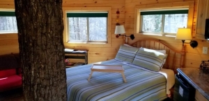 A cozy space welcomes guests in the octagonal Holly Rock Treehouse at Country Road Cabins.