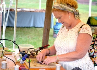 An artisan cuts stained glass at the Mountain State Art and Craft Fair at Ripley, West Virginia.