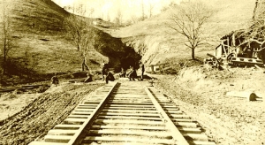 A vintage photo shows workers gathered outside the eastern portal of the Jenny Gap Tunnel.