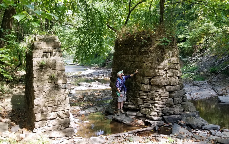 David Sibray inspects stonework in a thicket near the old saltworks.