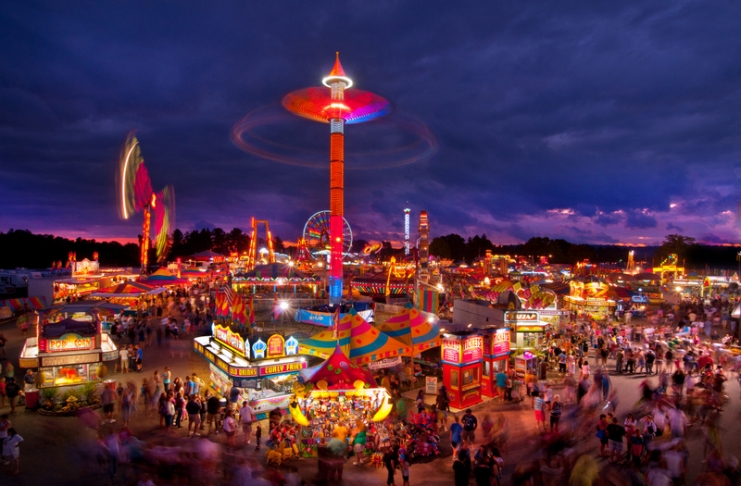 The midway at the State Fair of West Virginia rages with color at dusk at Fairlea, West Virginia.