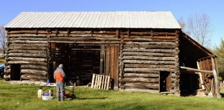 A researcher prepares to collect tree-ring samples from The Pitsenbarger Barn in Pendleton County.