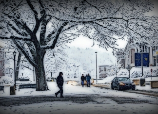 A student trudges across University Avenue near Woodburn Circle in Morgantown in winter. (Fhoto illustration by David Sibray)