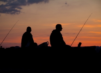 Anglers watch the sun set on a West Virginia lake.