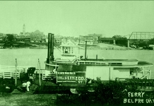 The Nina Paden docks at Belpre, Ohio. Parkersburg, with its tall courthouse tower, lines the Ohio River in the background.