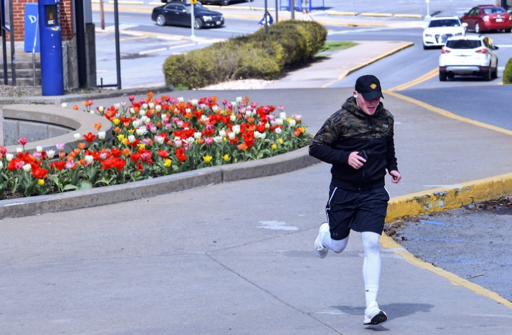 A jogger runs past the Chambers College of Business and Economics during the coronavirus outbreak.