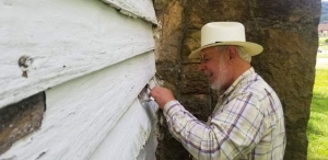 Jim Costa examines clapboard siding for signs of period construction methods.