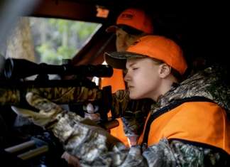 A young hunter aims from behind a blind in West Virginia.