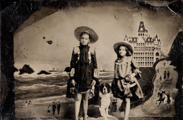 Two young girls pose for a vintage tintype portrait.