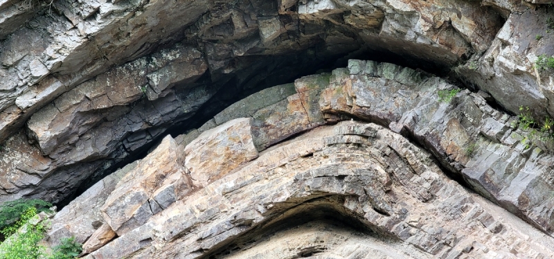 A close-up photograph shows the detail in the curving rock formation,