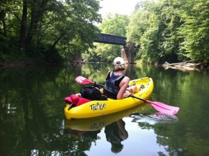 A kayaker leisurely paddles on a West Virginia flatwater trail.