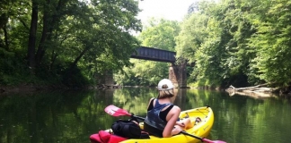 A kayaker leisurely paddles on a West Virginia flatwater trail.