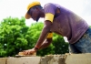 A mason repairs a brick wall.