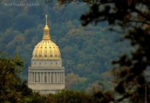 The gilded dome of the West Virginia Capitol stands out amid foliage at Charleston, West Virginia, in Kanawha County, in the Metro Valley Region.