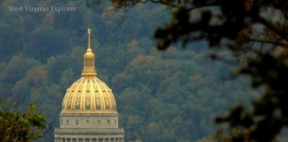 The gilded dome of the West Virginia Capitol stands out amid foliage at Charleston, West Virginia, in Kanawha County, in the Metro Valley Region.