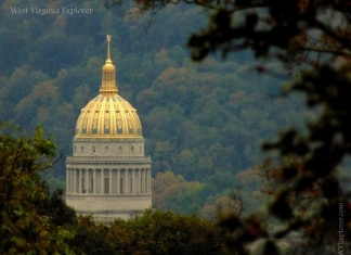 The gilded dome of the West Virginia Capitol stands out amid foliage at Charleston, West Virginia, in Kanawha County, in the Metro Valley Region.