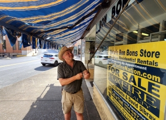David Sibray rolls out an awning in advance of a July 29 open house at Mount Hope.