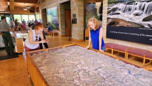 Sisters Pinky and Krissy Stiver explore a relief map in the Canyon Rim Visitor Center.