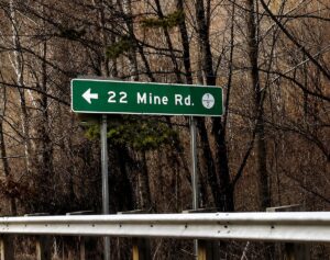 A highway sign points toward 22 Mine Road in Logan County, West Virginia, a road associated with one of the state’s enduring roadside ghost stories.