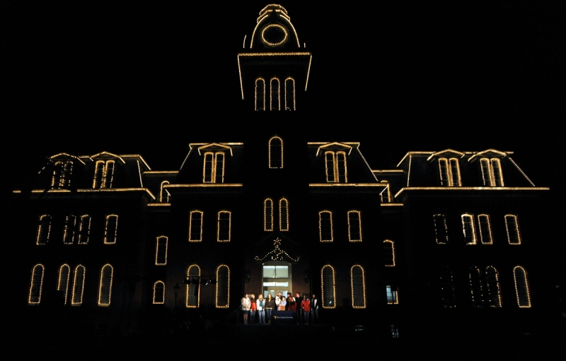 Woodburn Hall History: Holiday carolers sing outside the entrance to Woodburn Hall.