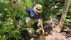 William Jones collects water from the site of a forgetten healing spring on the grounds of the Pence Springs Hotel.