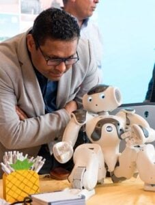 West Virginia University hotels and hospitality researcher Ajay Aluri interacts with a concierge robot. Aluri's research suggests artificial intelligence will increasingly handle routine hotel services while employees focus on delivering personalized guest experiences. (WVU Photo)