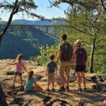 A family overlooks the New River Gorge Bridge from Long Point Trail in the New River Gorge National Park and Preserve near Fayetteville. The overlook is among West Virginia's most popular destinations for travelers exploring the Mountain State by road trip. (Photo: David Sibray)