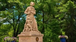 The Madonna of the Trail in Wheeling depicts a pioneer mother carrying an infant while a young child clings to her side and a rifle rests in her hand. Dedicated in 1928, the monument honors the courage and sacrifices of the women who helped lead their families west along the historic National Road. (Photo: David Sibray / WVExplorer)