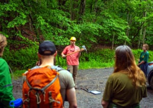 Logan Chapman of WVU’s Outdoor Economic Development Collaborative program explains tool use and trail safety to Peters Mountain Trail System volunteers. (Photo: Mon Forest Towns)