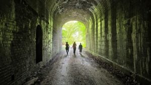 Visits walk through the tunnel on the rail trail at North Bend State Park.