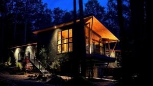 Warm, shielded exterior lighting allows this contemporary mountain home to remain welcoming after dark without overwhelming the surrounding landscape or diminishing views of the night sky. (Photo courtesy The Mills Group)