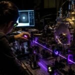 A researcher adjusts laser-based equipment used to study plasma behavior in a laboratory setting. Scientists at West Virginia University are developing new methods that could advance technologies ranging from semiconductor manufacturing to spacecraft propulsion and fusion energy.