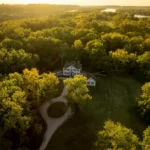 A drone view captures Blennerhassett Island Historical State Park in the Ohio River near Parkersburg, where the reconstructed Blennerhassett Mansion stands amid mature trees. Once the estate of Harman and Margaret Blennerhassett, the island became the setting for Aaron Burr's mysterious western expedition and today is one of West Virginia's most distinctive historic destinations.