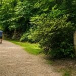 Visitors walk the Carriage Trail past the stone monument commemorating two unidentified women whose reported Civil War-era deaths remain one of Charleston's enduring historical mysteries.