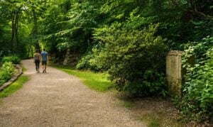 Visitors walk the Carriage Trail past the stone monument commemorating two unidentified women whose reported Civil War-era deaths remain one of Charleston's enduring historical mysteries.