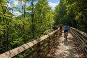 Cyclists ride the Rend Trail, one of the easiest and most scenic routes through New River Gorge National Park and Preserve. The historic former railroad corridor is scheduled to reopen in 2027 following an $11.8 million rehabilitation project.