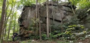 Gary Morefield sits in the shade of Ship Rock on the Ship Rock Trail, the first section of Beckley's Piney Creek trail system, which opened in 2013. More than a decade later, the Arc of Appalachia's acquisition of adjoining forestland has brought the long-envisioned trail connection to New River Gorge National Park and Preserve significantly closer to reality. (Photo: David Sibray)