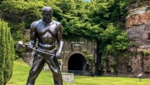 A statue of the legendary steel driver John Henry overlooks Great Bend Tunnel near Hinton. According to American folklore, John Henry died after defeating a steam drill during the tunnel's construction, a project that helped transform one of Appalachia's most isolated river valleys into a major transportation corridor.
