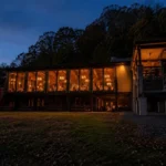 Mountain Creek Lodge glows in the evening at the bottom of West Virginia's Bluestone Gorge, where the new Mountain Creek Appalachian Cuisine restaurant welcomes diners arriving by Pipestem Resort State Park's iconic aerial tram.