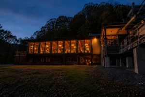 Mountain Creek Lodge glows in the evening at the bottom of West Virginia's Bluestone Gorge, where the new Mountain Creek Appalachian Cuisine restaurant welcomes diners arriving by Pipestem Resort State Park's iconic aerial tram.
